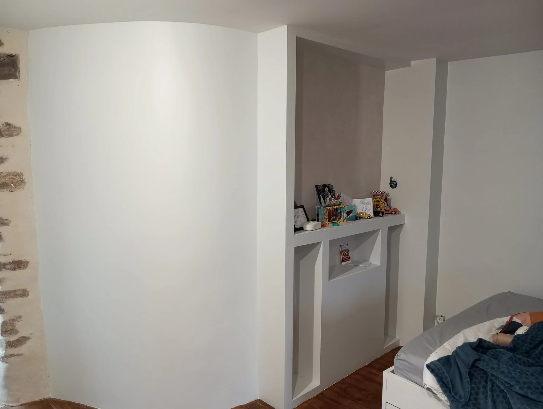 Aménagement intérieur avec cloison arrondie et niche décorative pour meuble TV